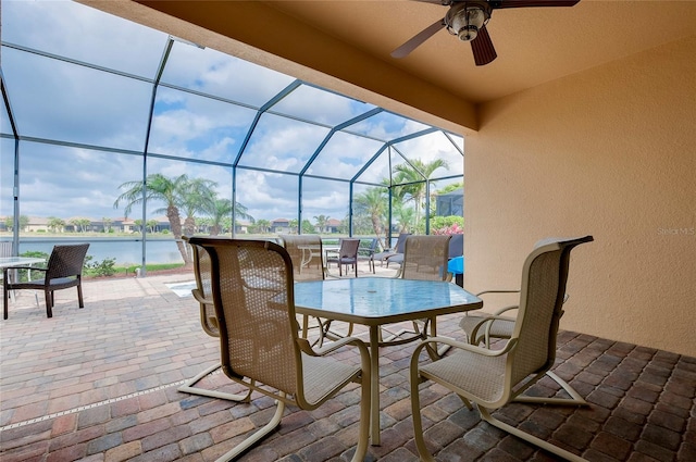 view of patio / terrace with a water view, ceiling fan, and glass enclosure