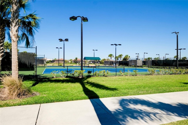 view of community featuring tennis court and a lawn