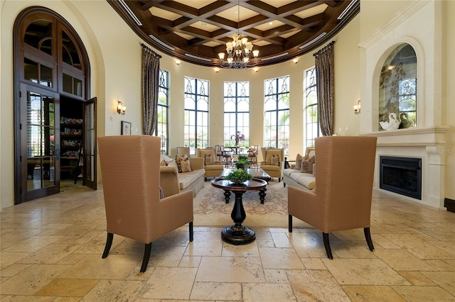 sitting room featuring a high ceiling, coffered ceiling, an inviting chandelier, and beamed ceiling