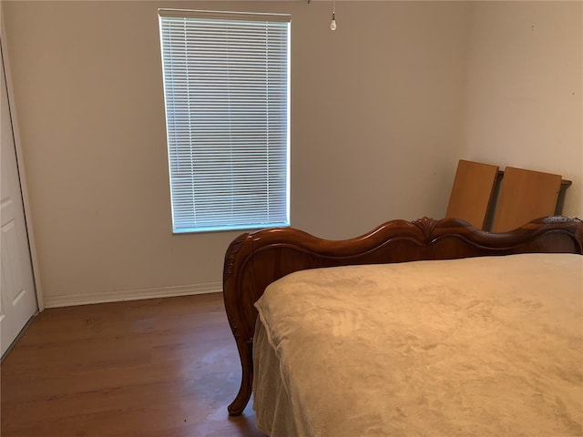 bedroom with baseboards and wood finished floors