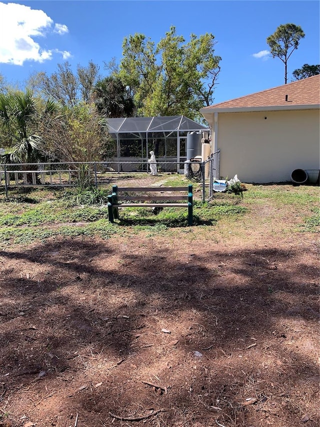 view of yard with fence and a lanai