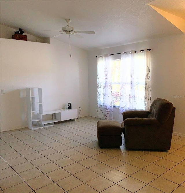 sitting room with light tile patterned floors, vaulted ceiling, and ceiling fan