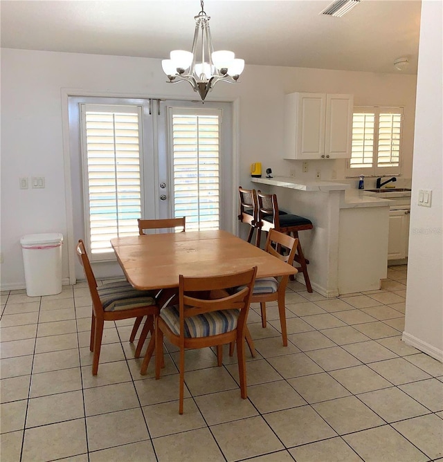 dining area with french doors, light tile patterned floors, baseboards, visible vents, and a notable chandelier