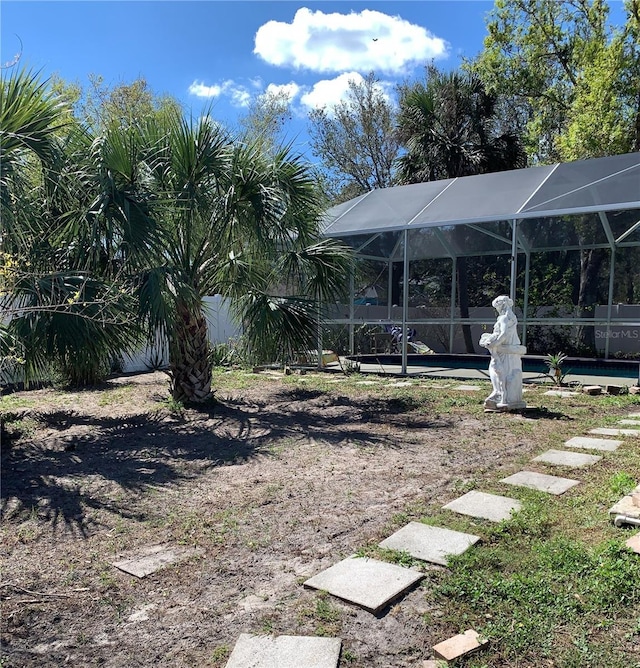view of yard featuring a swimming pool and glass enclosure