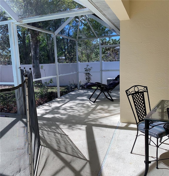 view of patio featuring a lanai and fence