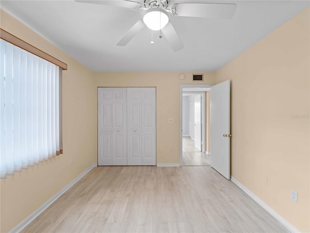 unfurnished bedroom with light hardwood / wood-style floors, a closet, and ceiling fan