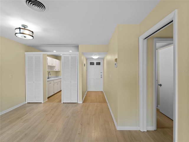 hall with sink and light hardwood / wood-style flooring