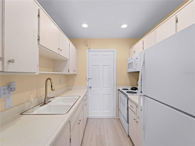 kitchen featuring white cabinetry, white appliances, sink, and light hardwood / wood-style flooring