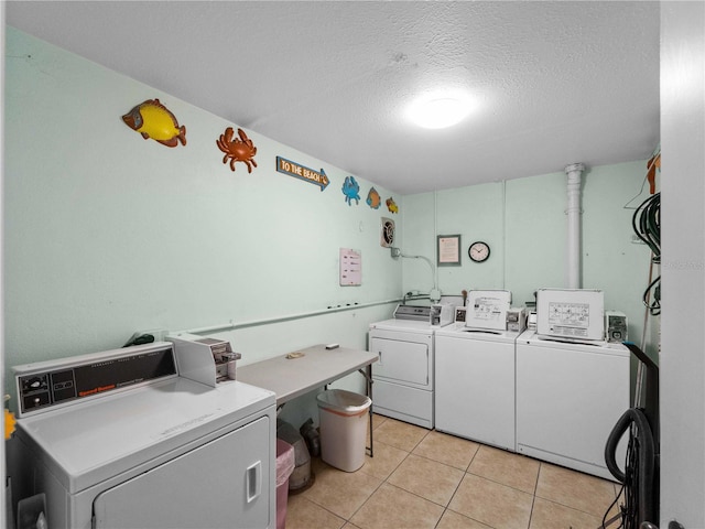 laundry area with light tile patterned flooring, independent washer and dryer, and a textured ceiling