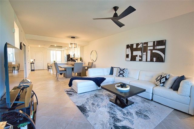 living area featuring light tile patterned floors and a ceiling fan