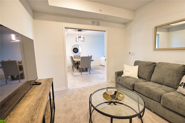 living area featuring baseboards, visible vents, and light colored carpet