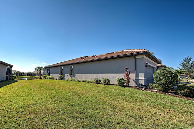 view of home's exterior with a garage and a lawn