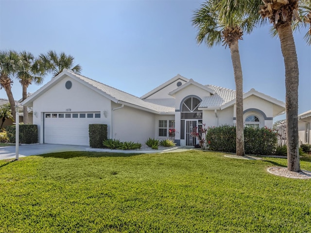 ranch-style home with a garage and a front lawn