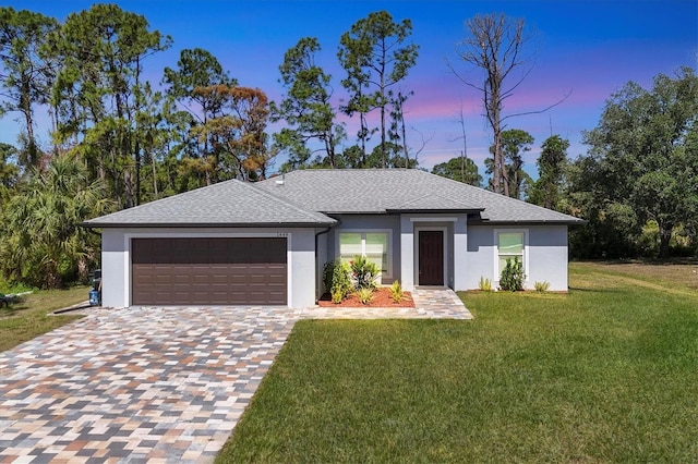 view of front of home featuring a garage and a yard