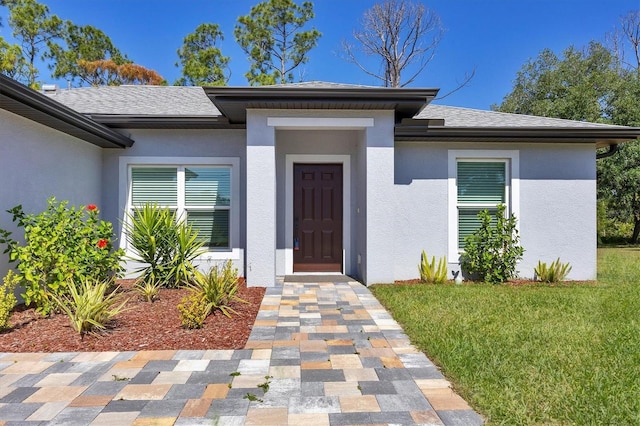 doorway to property with a lawn