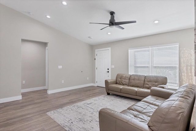 living room featuring lofted ceiling, light hardwood / wood-style floors, and ceiling fan