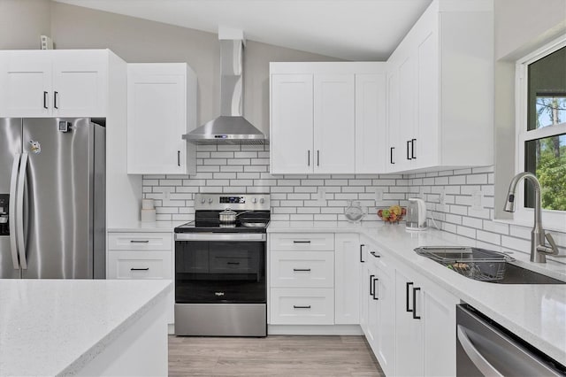 kitchen featuring stainless steel appliances, sink, wall chimney range hood, and white cabinets