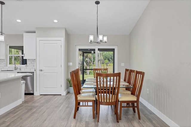 dining area featuring a chandelier, sink, and light hardwood / wood-style flooring