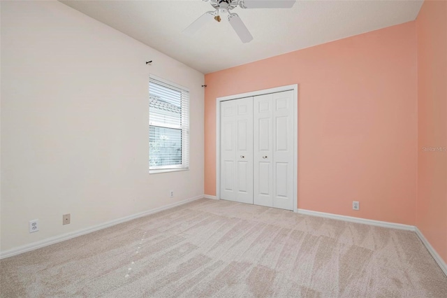 unfurnished bedroom featuring light colored carpet, ceiling fan, and a closet