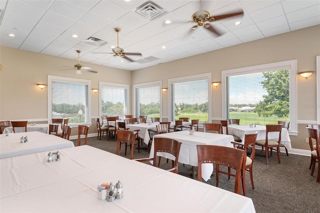 dining room featuring ceiling fan and dark colored carpet