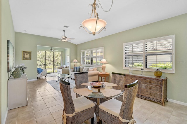 dining room with ceiling fan, vaulted ceiling, and light tile patterned floors