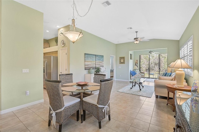 dining room with ceiling fan, vaulted ceiling, and light tile patterned floors