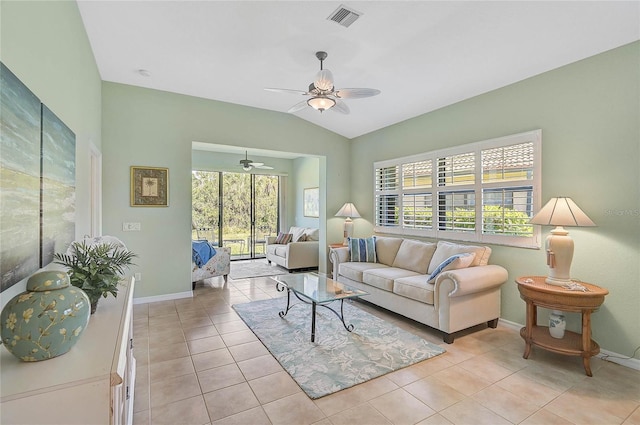 living room featuring vaulted ceiling, plenty of natural light, light tile patterned floors, and ceiling fan