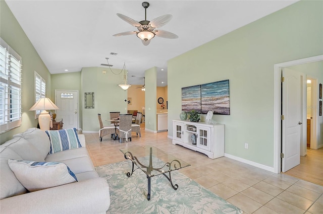 living room featuring ceiling fan, vaulted ceiling, and light tile patterned floors