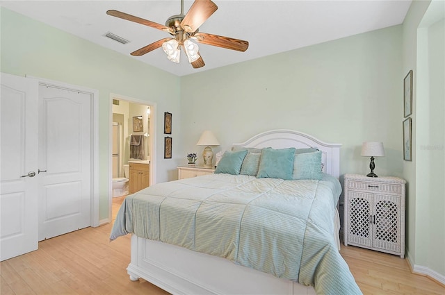 bedroom featuring ceiling fan, light hardwood / wood-style floors, and ensuite bath