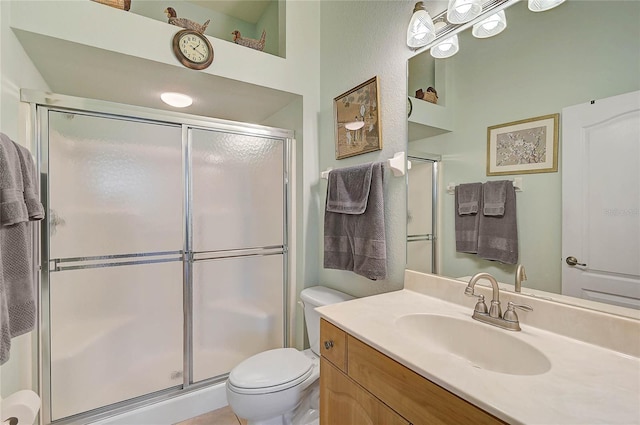 bathroom with vanity, a shower with shower door, and toilet