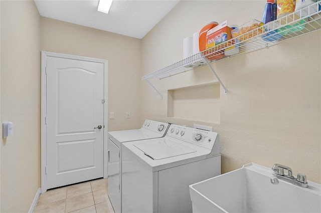 laundry room with sink, washer and clothes dryer, and light tile patterned flooring