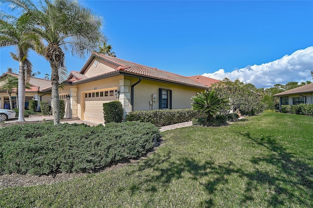 view of side of home featuring a garage and a lawn