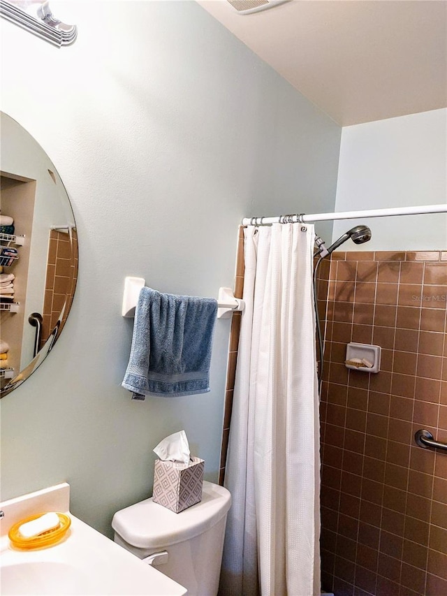 bathroom featuring a shower with curtain and toilet