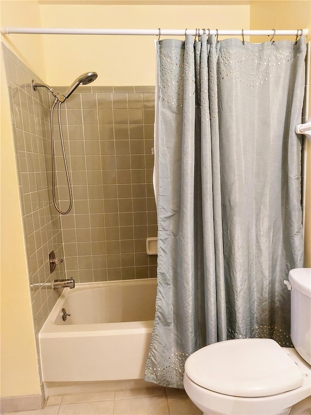 bathroom featuring tile patterned flooring, shower / bath combo with shower curtain, and toilet