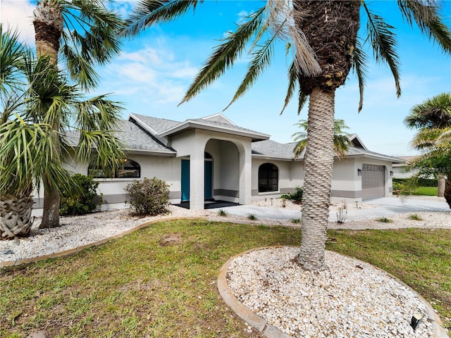 view of front of home with an attached garage, a shingled roof, concrete driveway, stucco siding, and a front lawn