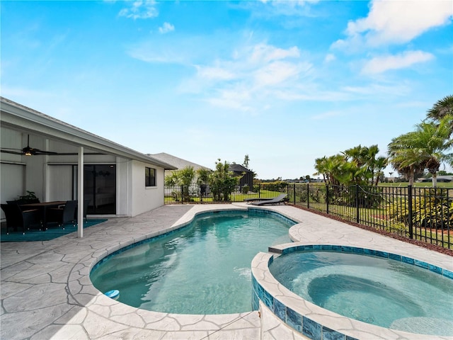 view of swimming pool featuring a pool with connected hot tub, fence, and a patio