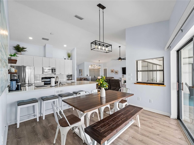 dining space with a ceiling fan, baseboards, visible vents, and wood finished floors