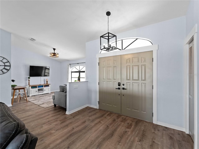 entrance foyer featuring baseboards, visible vents, a chandelier, and wood finished floors