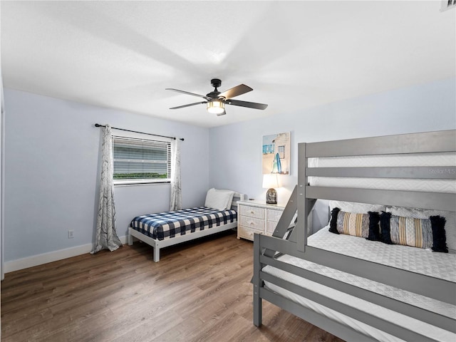 bedroom featuring ceiling fan, baseboards, and wood finished floors