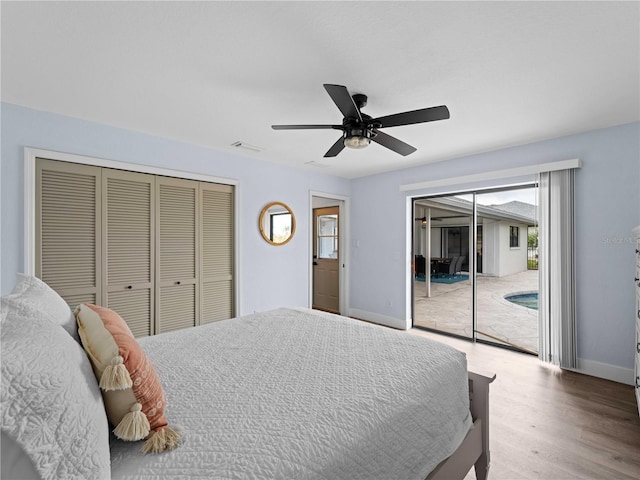 bedroom with access to exterior, visible vents, a ceiling fan, wood finished floors, and baseboards