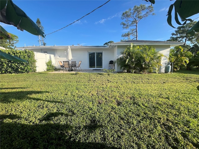 rear view of property with a patio area and a lawn