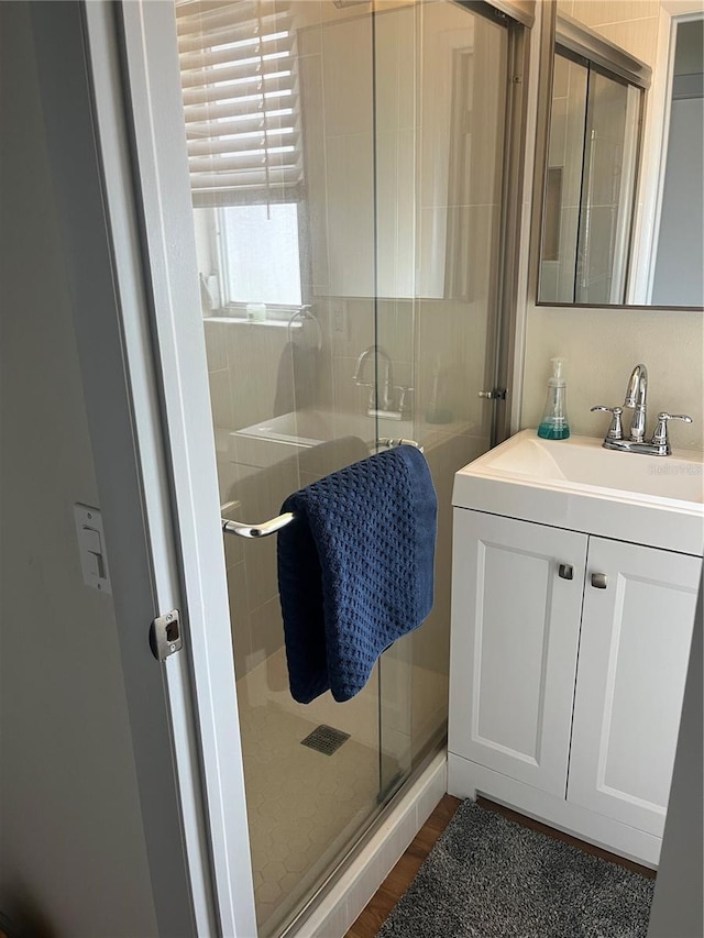 bathroom with vanity, wood-type flooring, and walk in shower