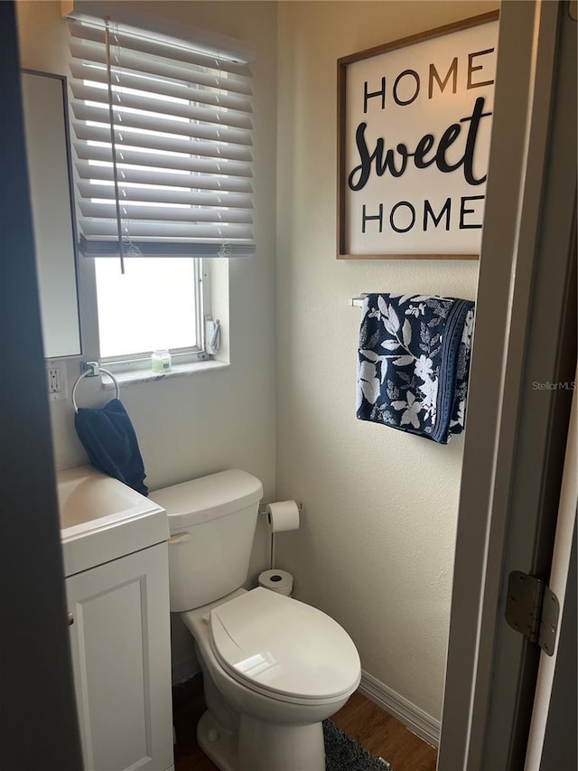 bathroom featuring wood-type flooring, vanity, and toilet