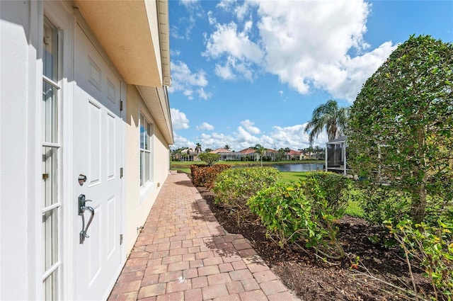 view of side of home with a water view and a lanai