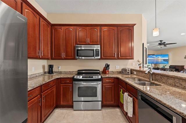 kitchen featuring sink, appliances with stainless steel finishes, pendant lighting, ceiling fan, and light stone countertops