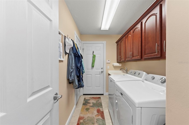 laundry area with cabinets, separate washer and dryer, sink, and light tile patterned floors