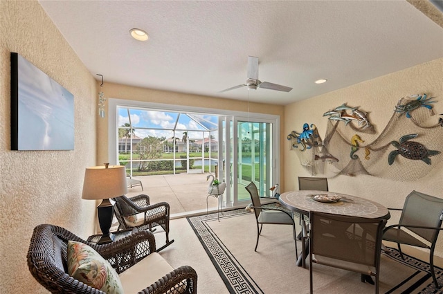 dining space featuring ceiling fan and a textured ceiling