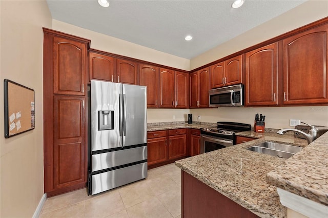 kitchen featuring light tile patterned flooring, sink, light stone counters, a textured ceiling, and stainless steel appliances