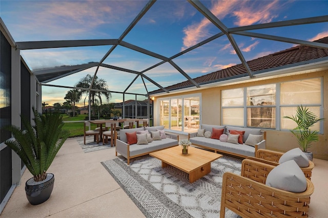 patio terrace at dusk featuring an outdoor hangout area and glass enclosure