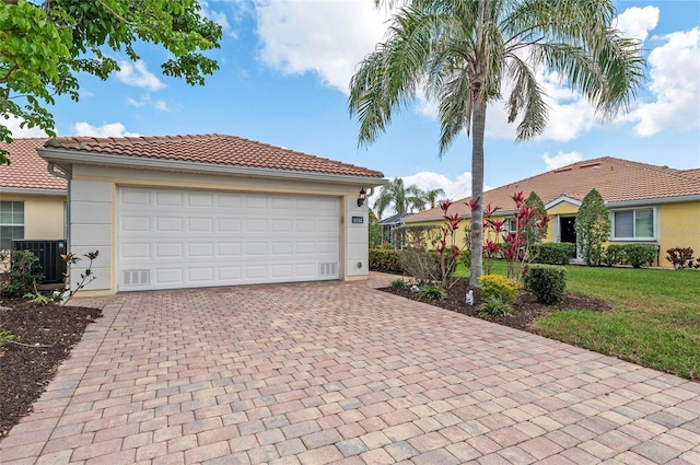 view of front of property featuring a garage, a front yard, and central air condition unit